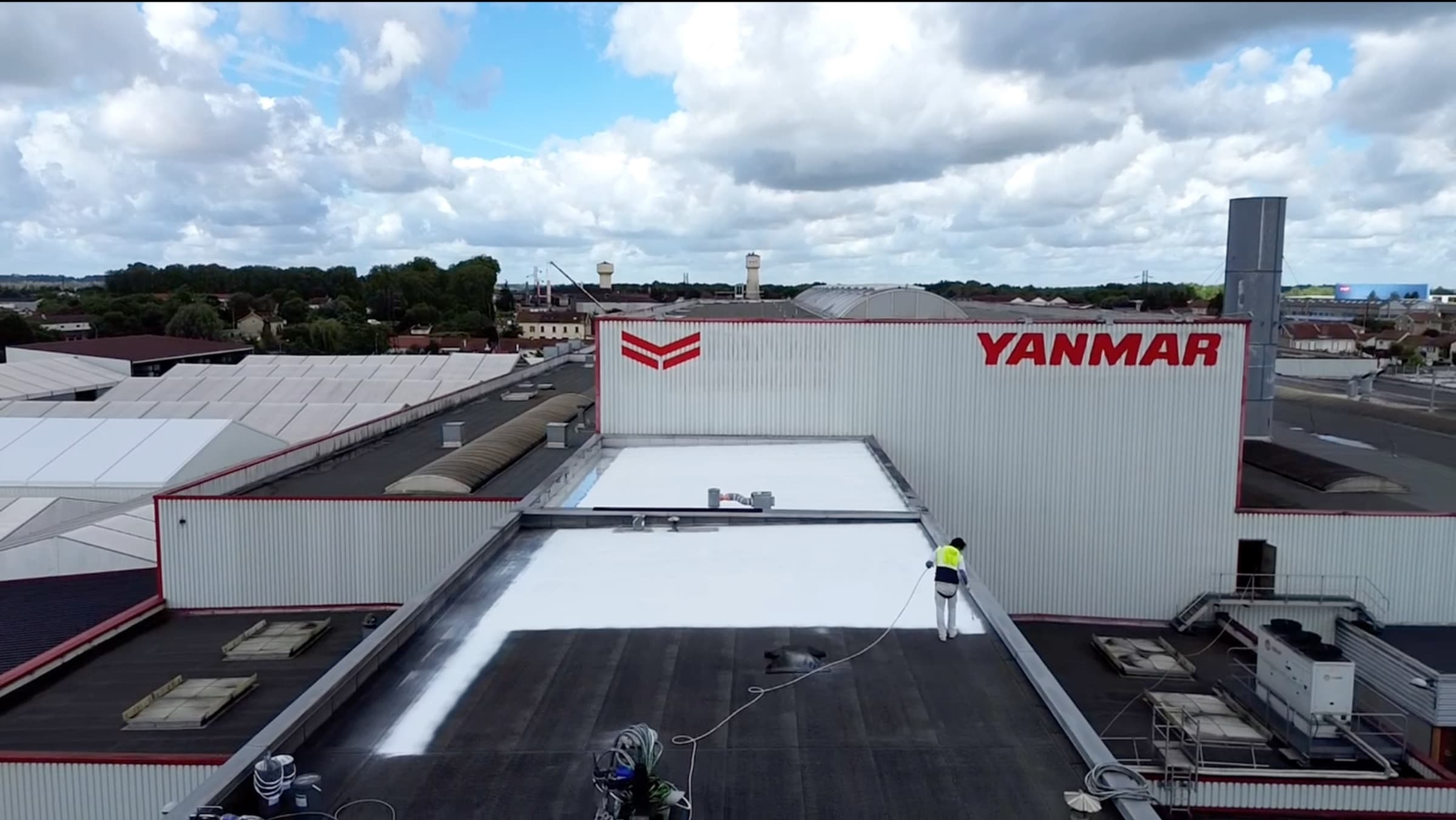 Application du revêtement Cool Roofing blanc sur la toiture à membrane noire des bureaux Yanmar à Saint-Dizier